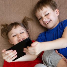 two-small-children-are-making-faces-at-mobile-phone-camera